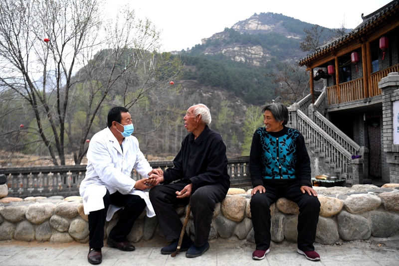 2020年4月15日,在河北阜平县龙泉关镇骆驼湾村,村医霍建国为村民把脉。