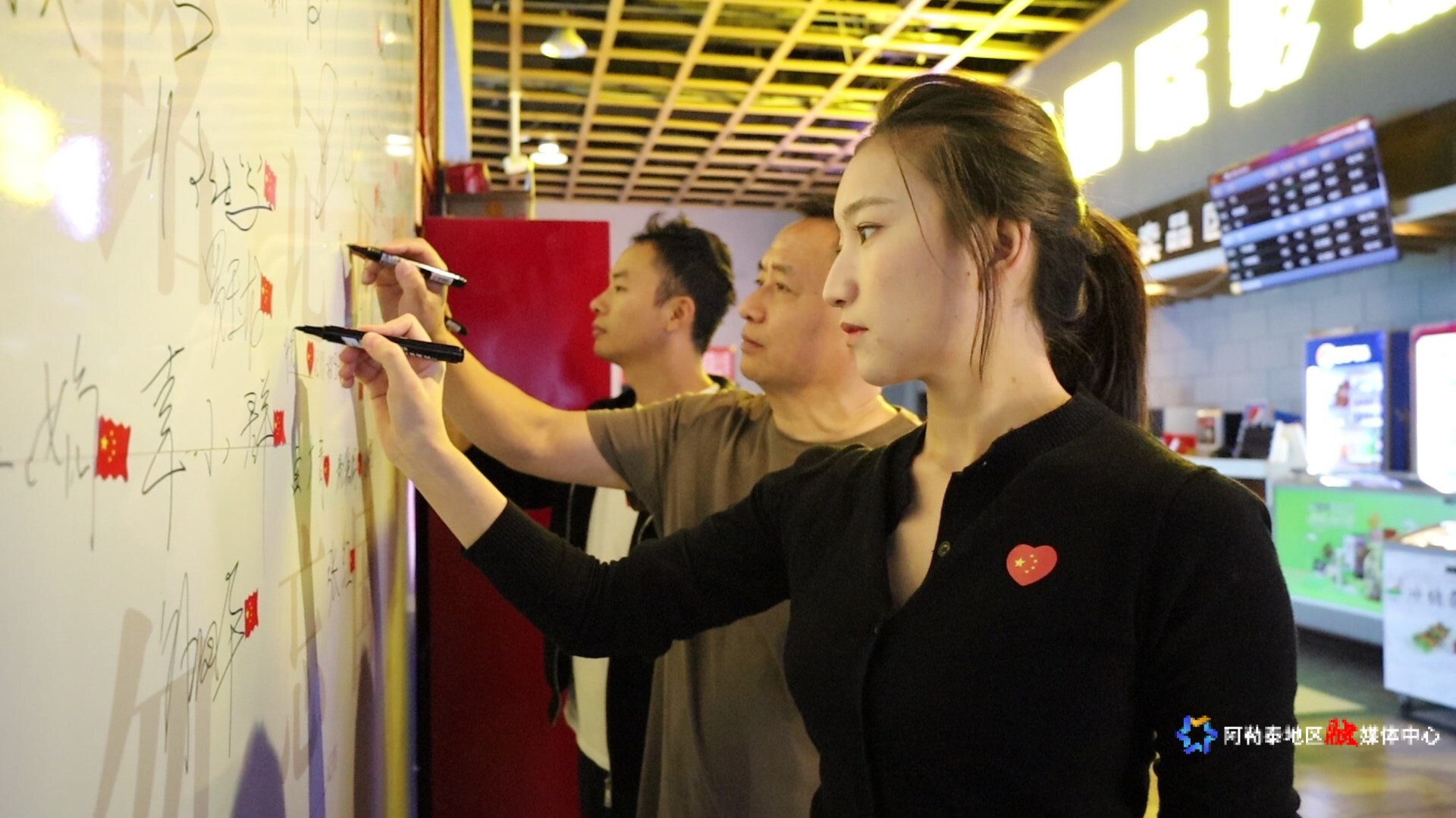 在雪影国际影城内,观看电影《731》的观众们正在专门设立的观影心声墙上签名。2