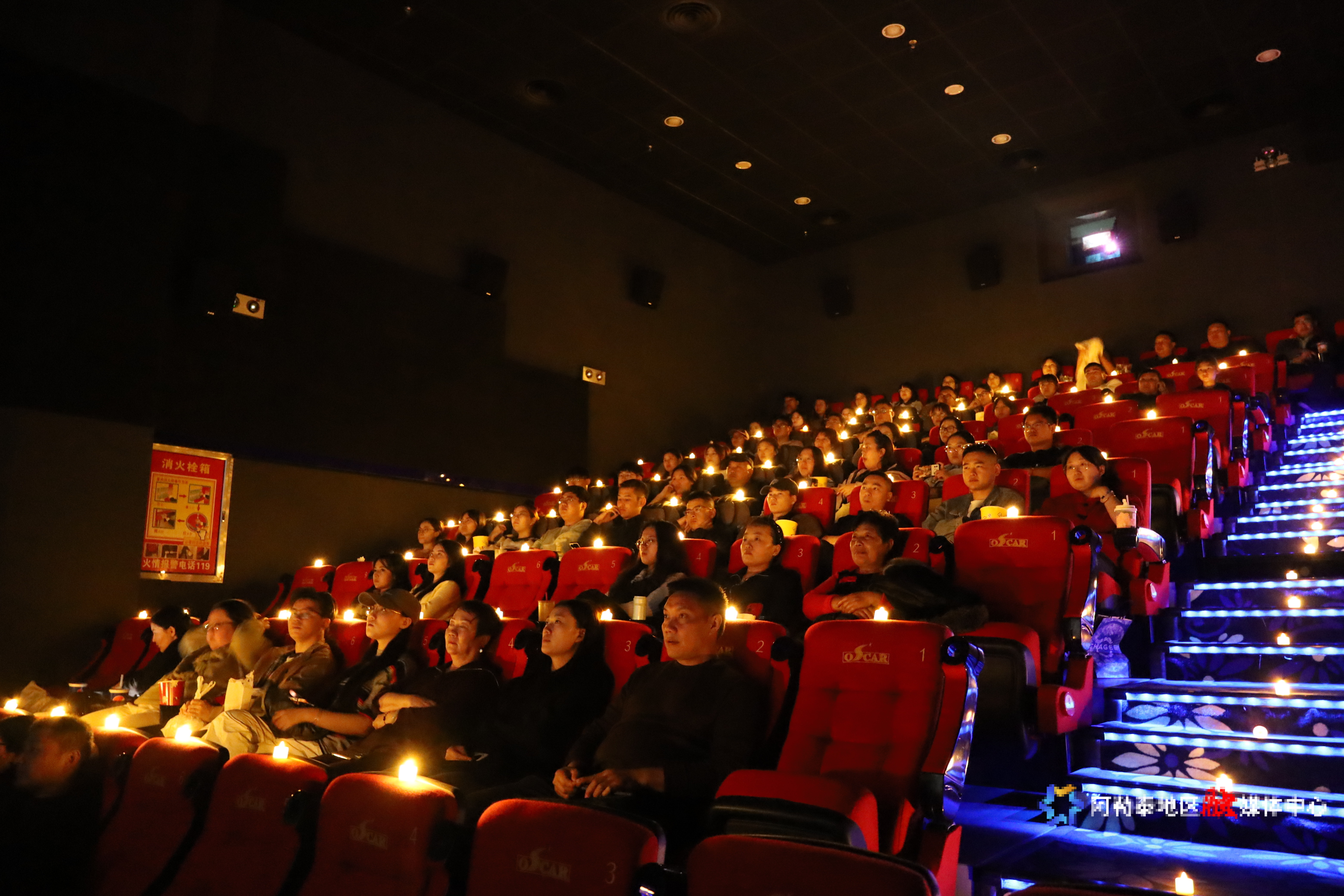 在新强奥斯卡影院设立的微光应史 向光而行 出口有光--纪念场内,观众们正在观看影片。